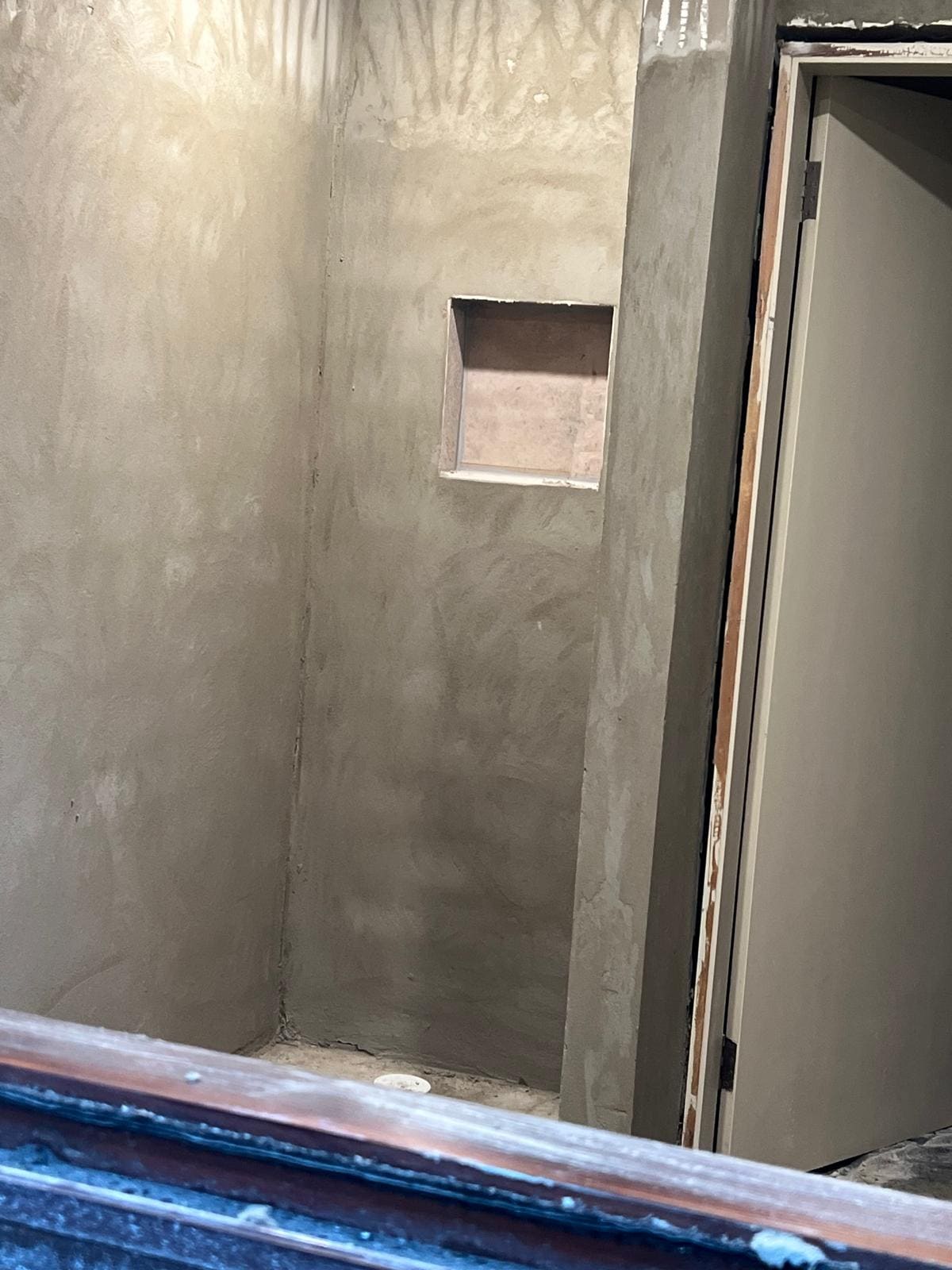 Shower recess in a Sydney bathroom cement rendered with a built in niche shelf ready for waterproofing