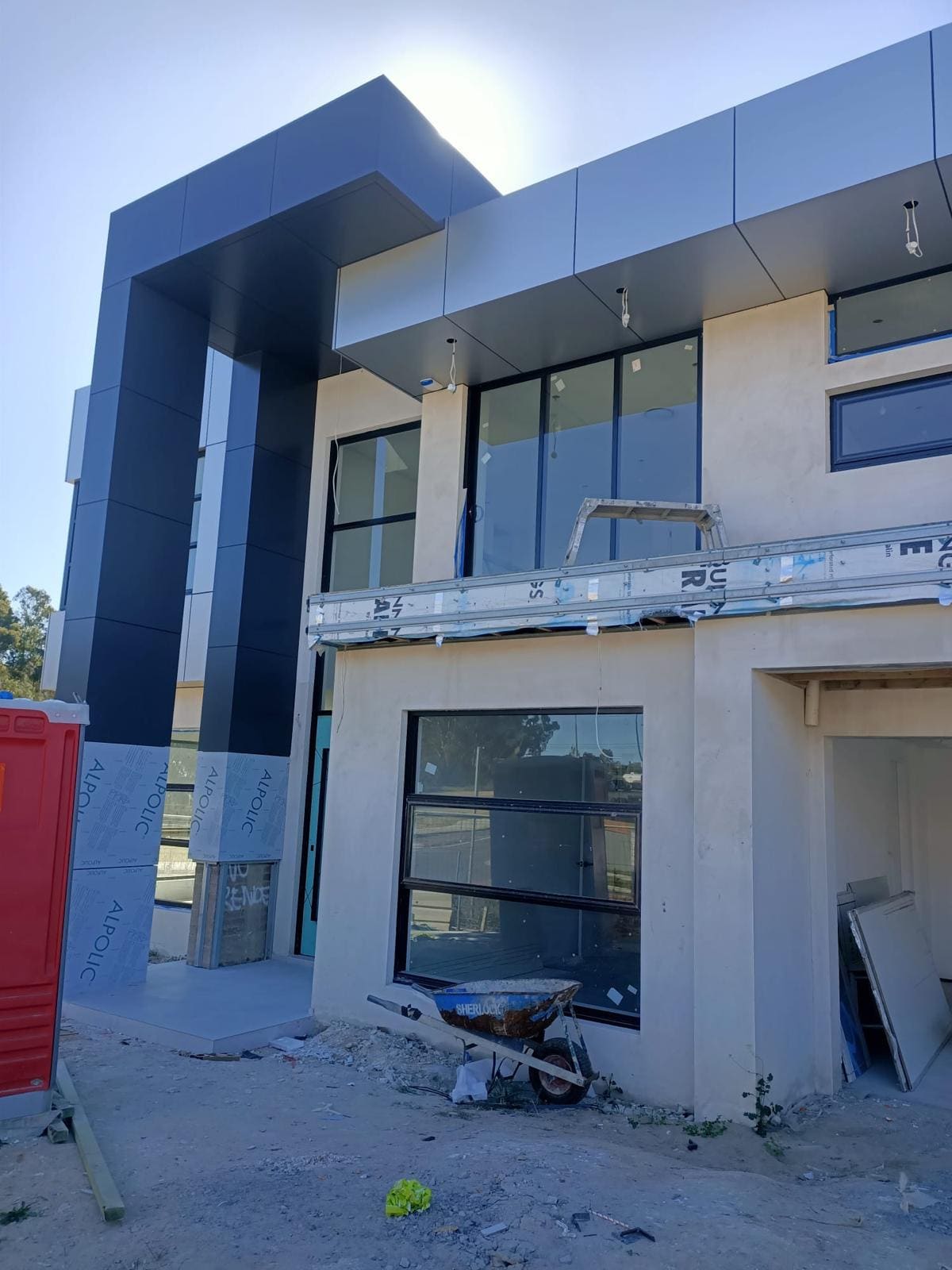 Modern commercial building in Sydney with rendered walls between dark aluminium composite cladding panels