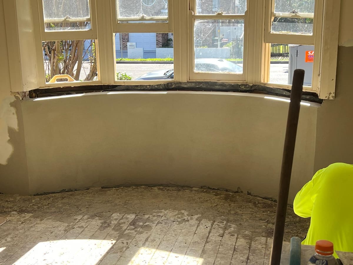 Curved bay window wall inside a heritage Sydney home freshly rendered and floated smooth