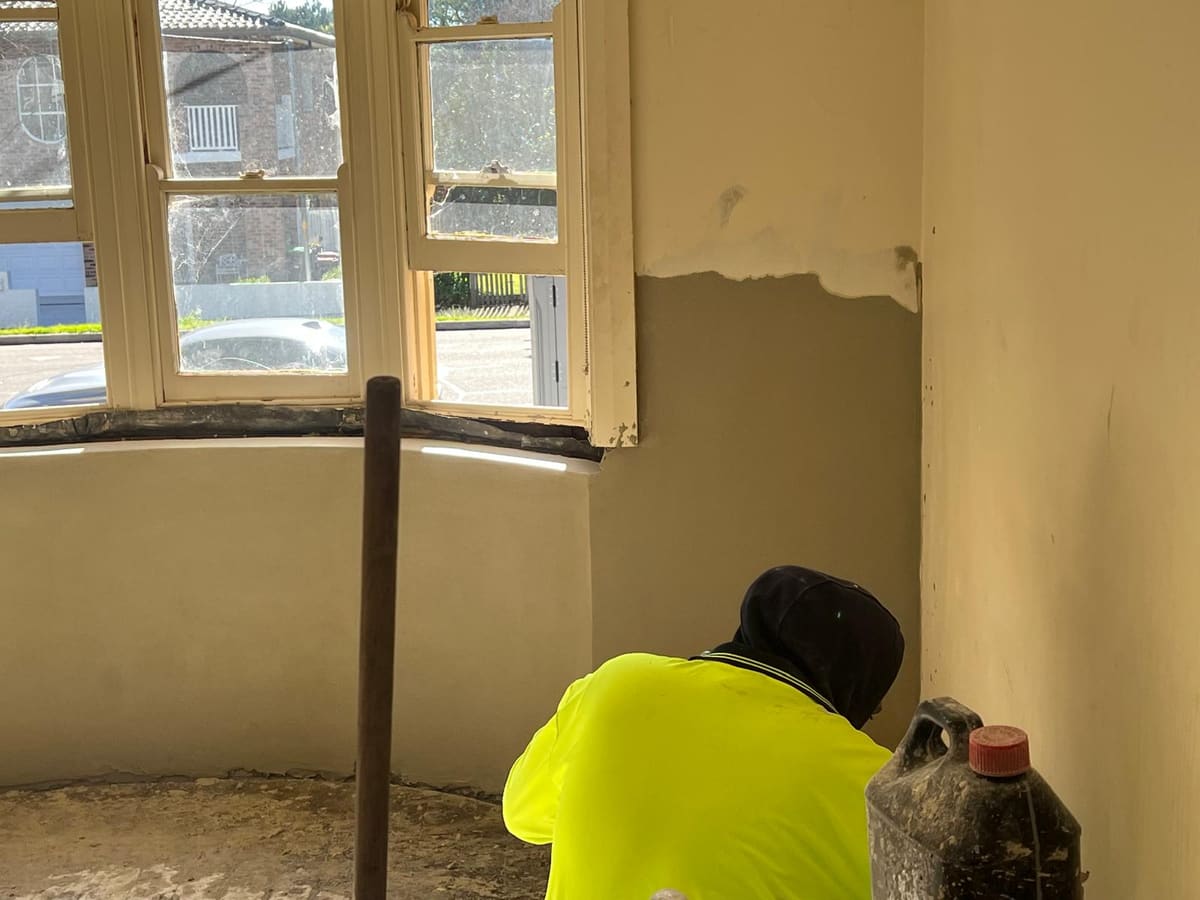 Renderer working on the curved bay window wall inside a heritage Sydney home