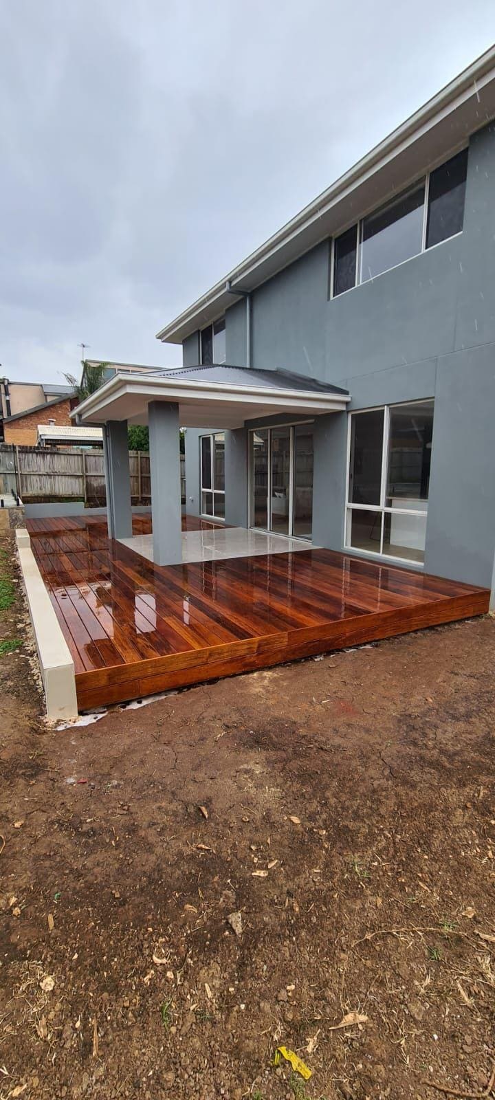 Two storey Sydney home finished in smooth grey cement render with a polished hardwood deck