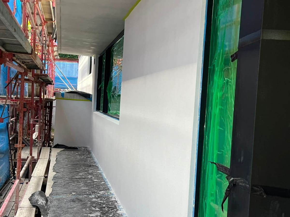 Rendered walkway wall along a Sydney new build with scaffolding still up and the finish complete
