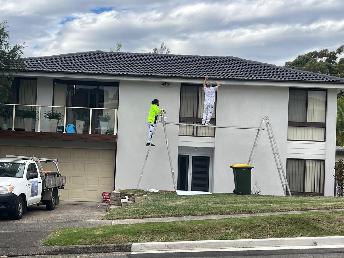 Two SPR Rendering tradesmen working from a plank on the facade of a Sydney home